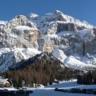 Południowy Tyrol, Austria. Widok na ośnieżone szczyty. U stóp gór pensjonaty oraz drzewa.